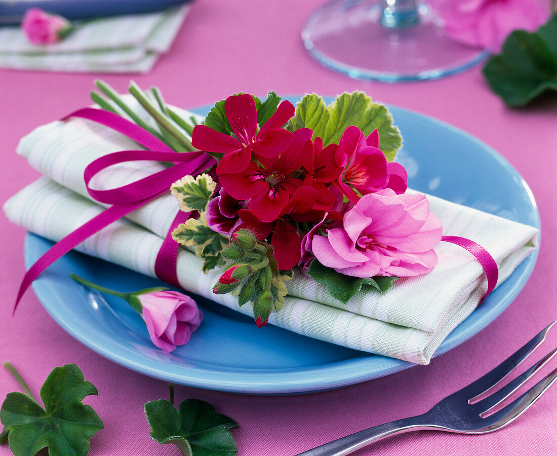 Kleiner Strauß aus Pelargonium (Geranien) auf Serviette,