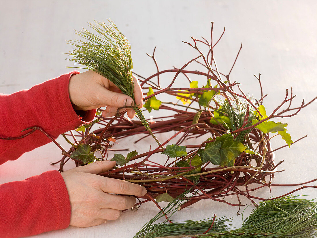 Adventskranz mit roten Kugeln, Zweigen und Efeu (3/6)