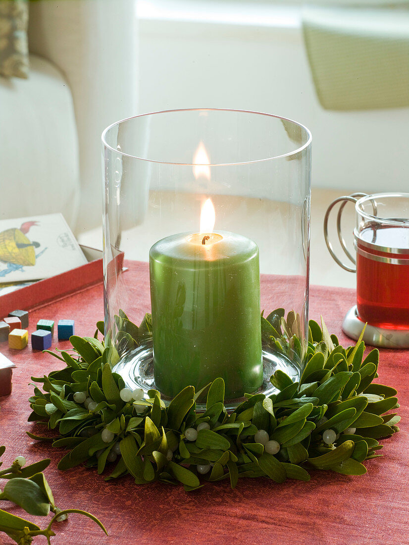 Lantern with wreath of Viscum album (mistletoe) and green candle