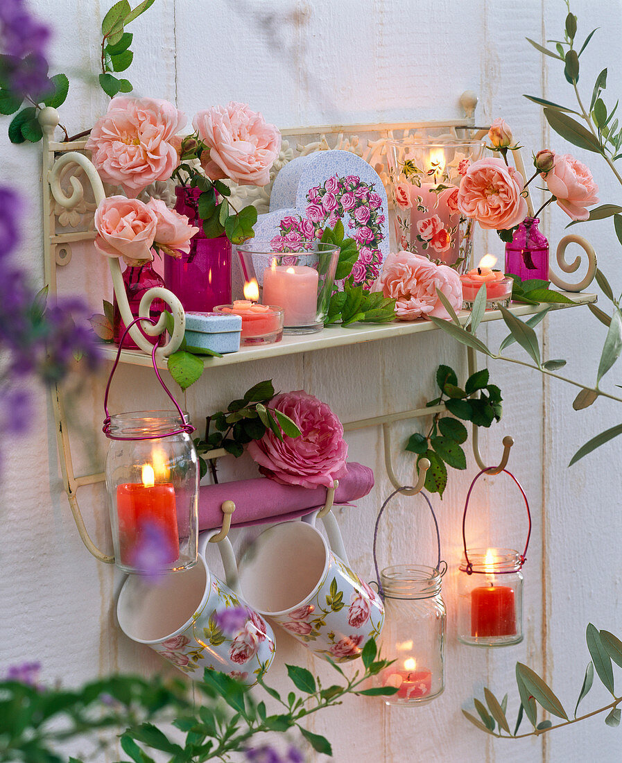 Wall shelf decorated with pink, cups, lanterns, box of roses