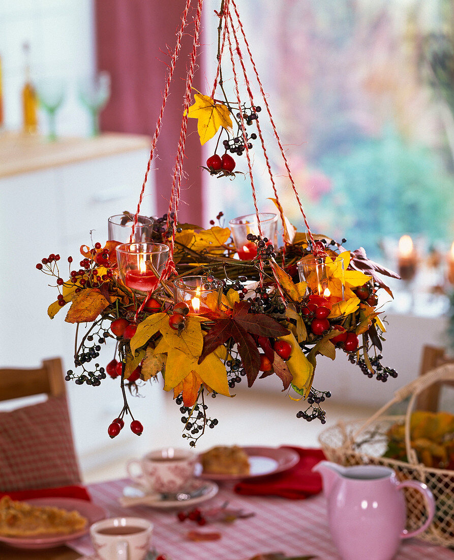 Hanging wreath with autumn leaves of liquidambar, rosehips and berries