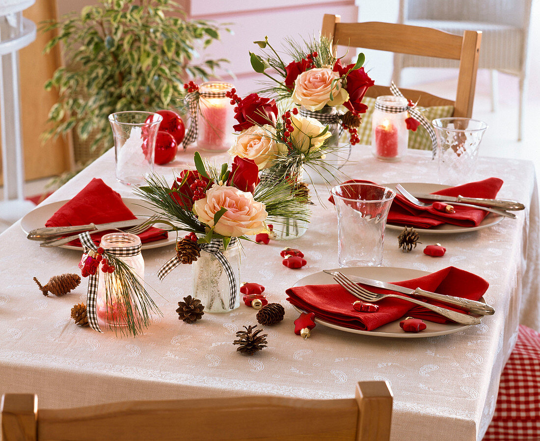 Table decoration with small bouquets of rose, pinus, Ilex