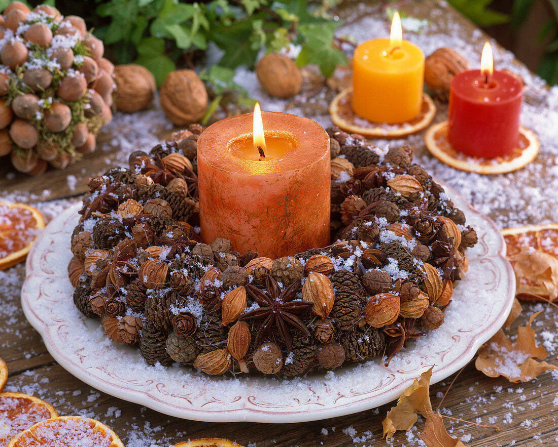 Wreath with cones, star anise, dried fruits around candle