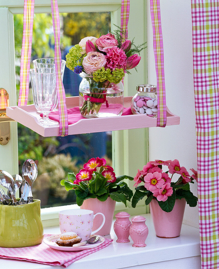 Spring window with Primula acaulis (spring primroses) in a pot