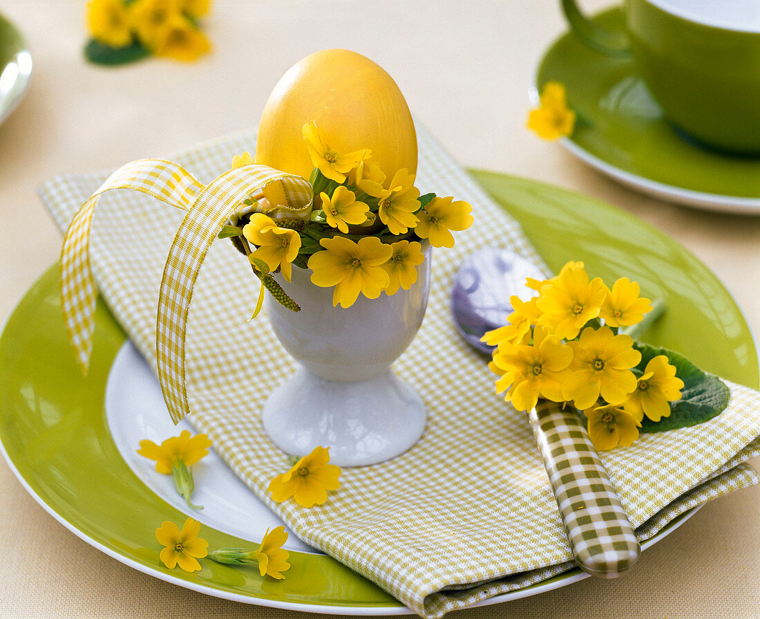 Tellerdekoration mit Schlüsselblumen am Osterei und auf dem Teller