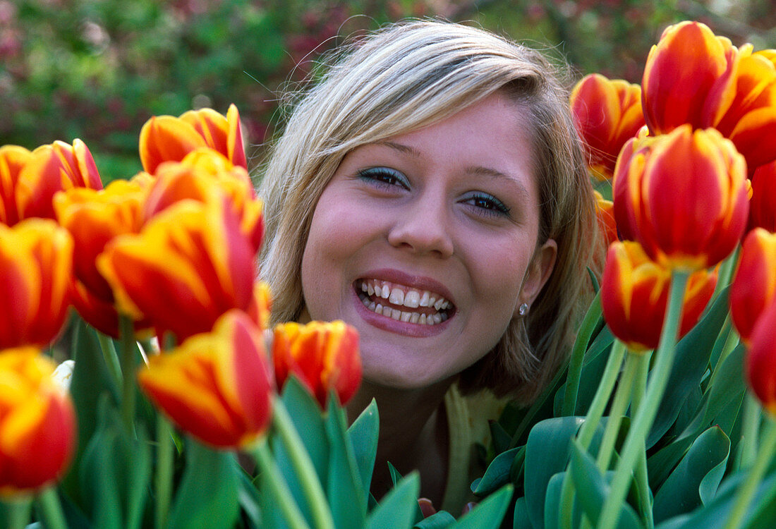 Woman between Tulipa 'Bright Side' (tulips)