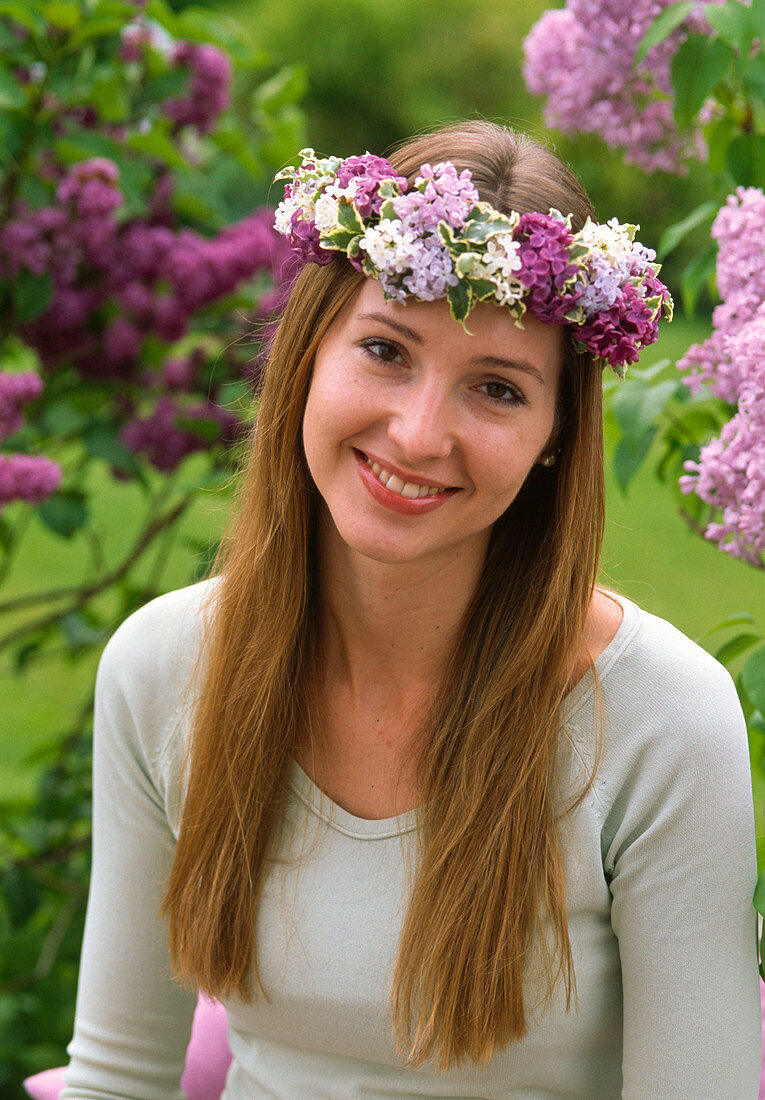 Woman with a wreath of Syringa (lilac) and Pittosporum