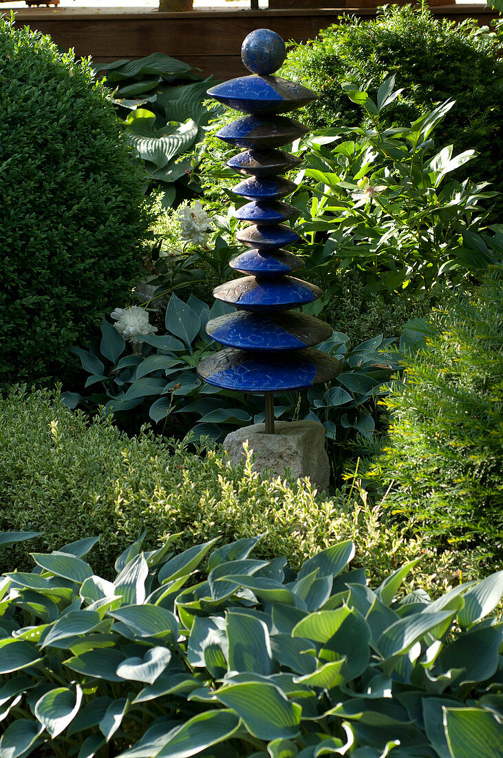Sculpture made of blue clay discs with a ball as top