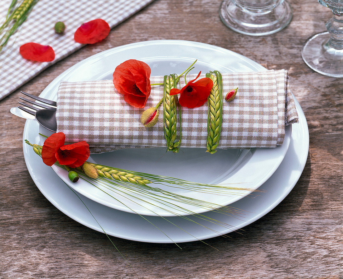 Serviettendekoration mit Papaver (Klatschmohn) und Hordeum (Gerste)