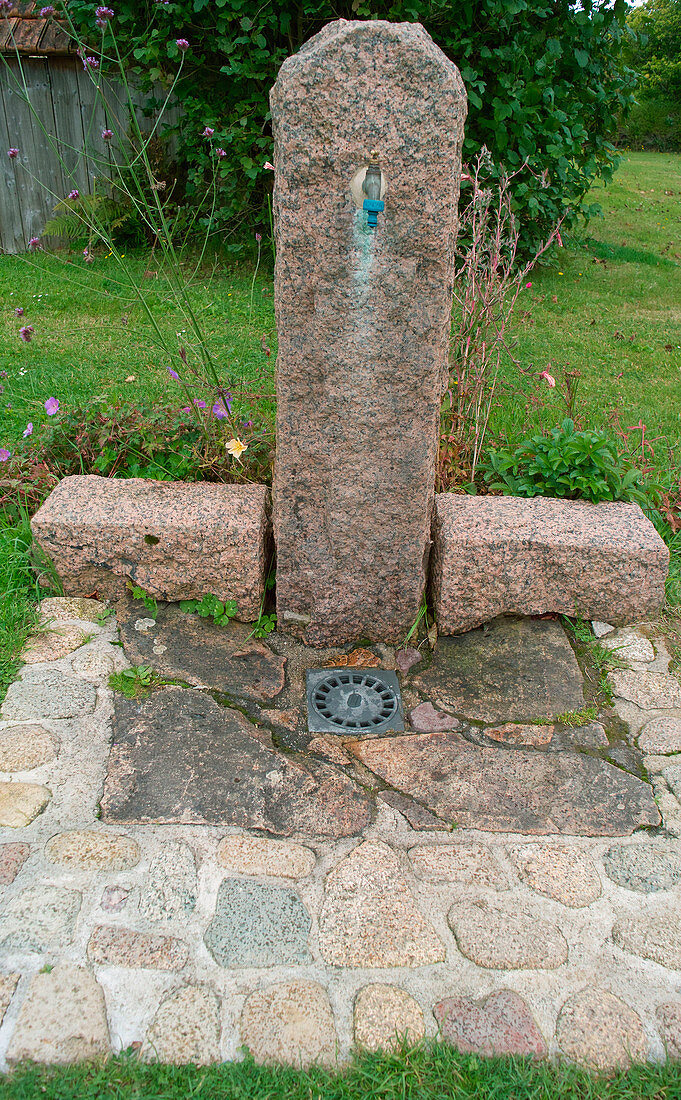 Wasserstelle an freistehender Granitsäule mit Abfluß im Boden