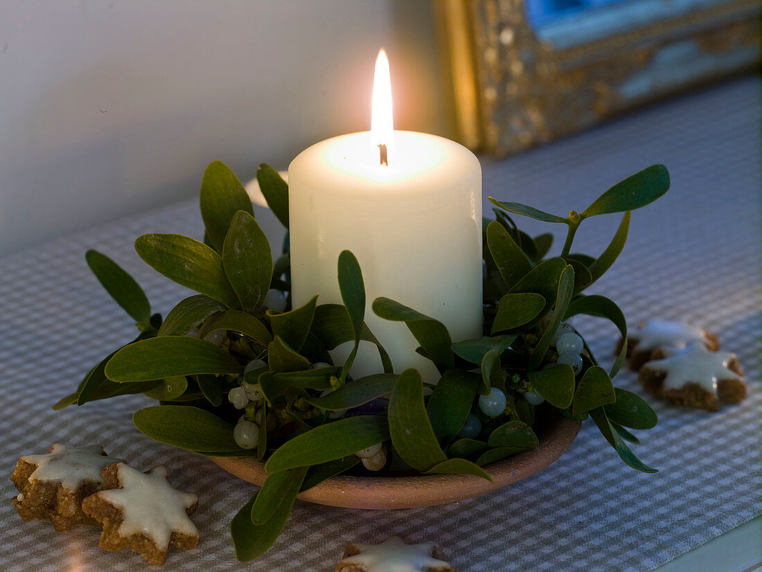 White candle with Viscum album (mistletoe)