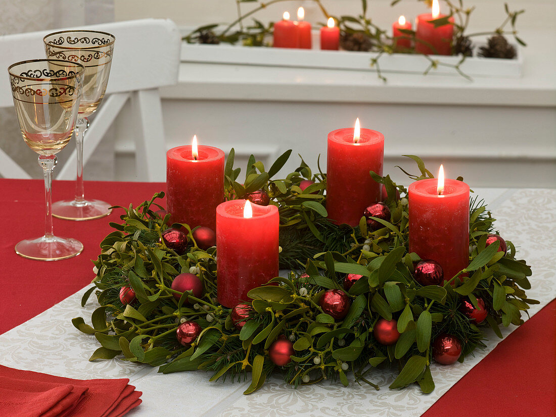 Advent wreath made of Viscum album with red candles and balls