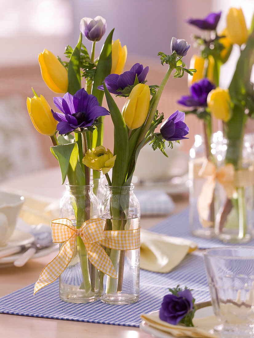 Tulipa (tulips), anemone (anemones) in small glass bottles