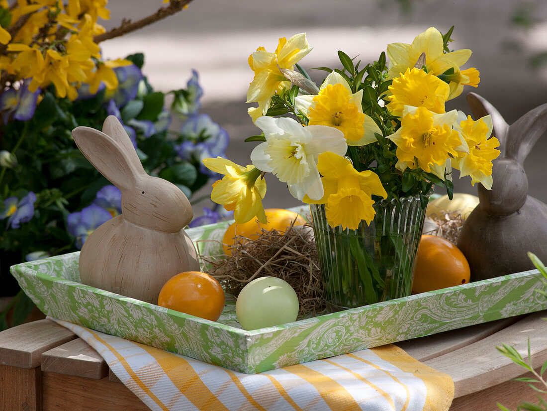 Kleiner Strauß aus Narcissus (Narzissen) auf Tablett mit Osterhasen