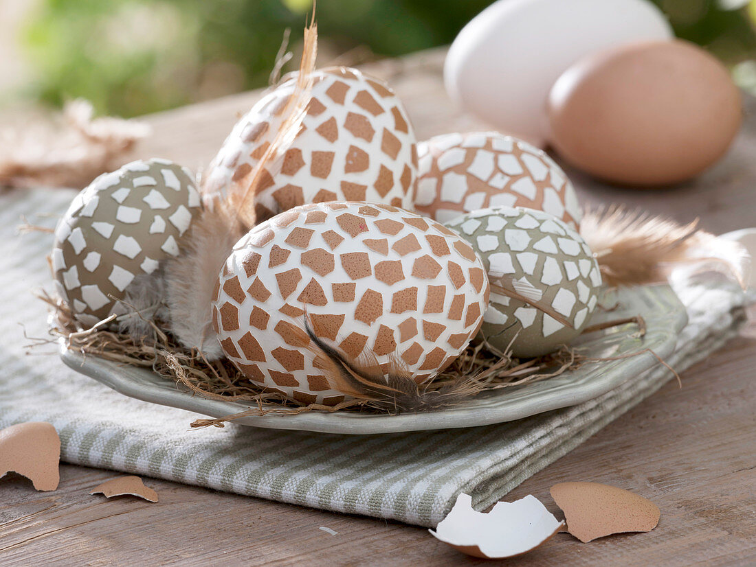 Ostereier in Naturfarben beklebt mit weißen und braunen Eierschalenstücken
