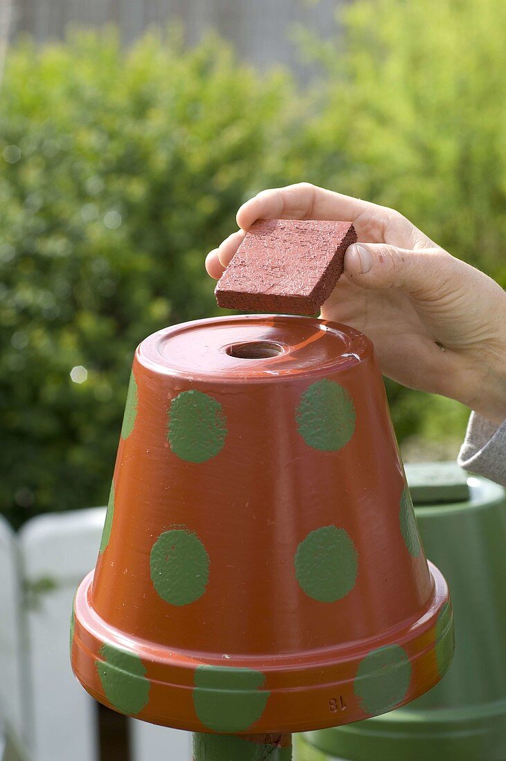 Colorfully painted clay pots on piles as beneficial shelter