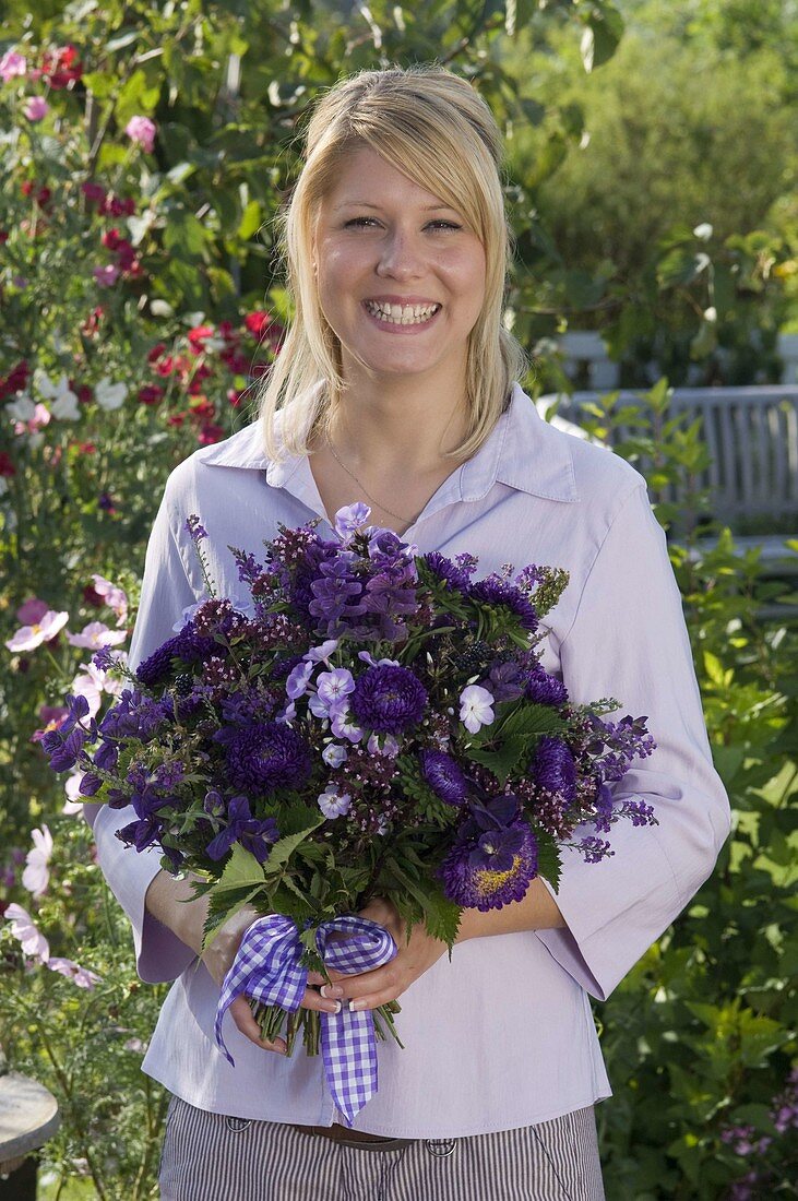 Young woman with bouquet of Callistephus (Summer Aster), Salvia horminium