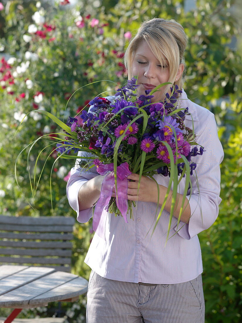 Young woman with bouquet of Callistephus (Summer Aster), Erigeron