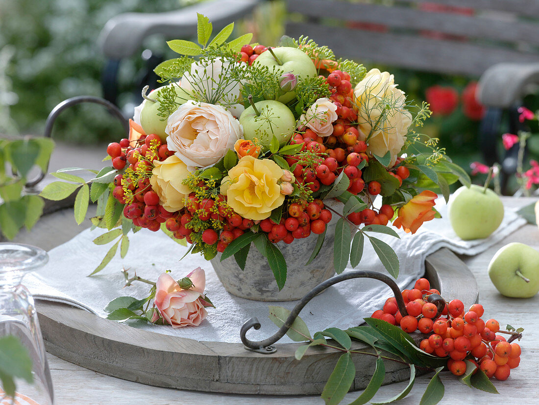 Late summer bouquet with roses, apples and rowanberries