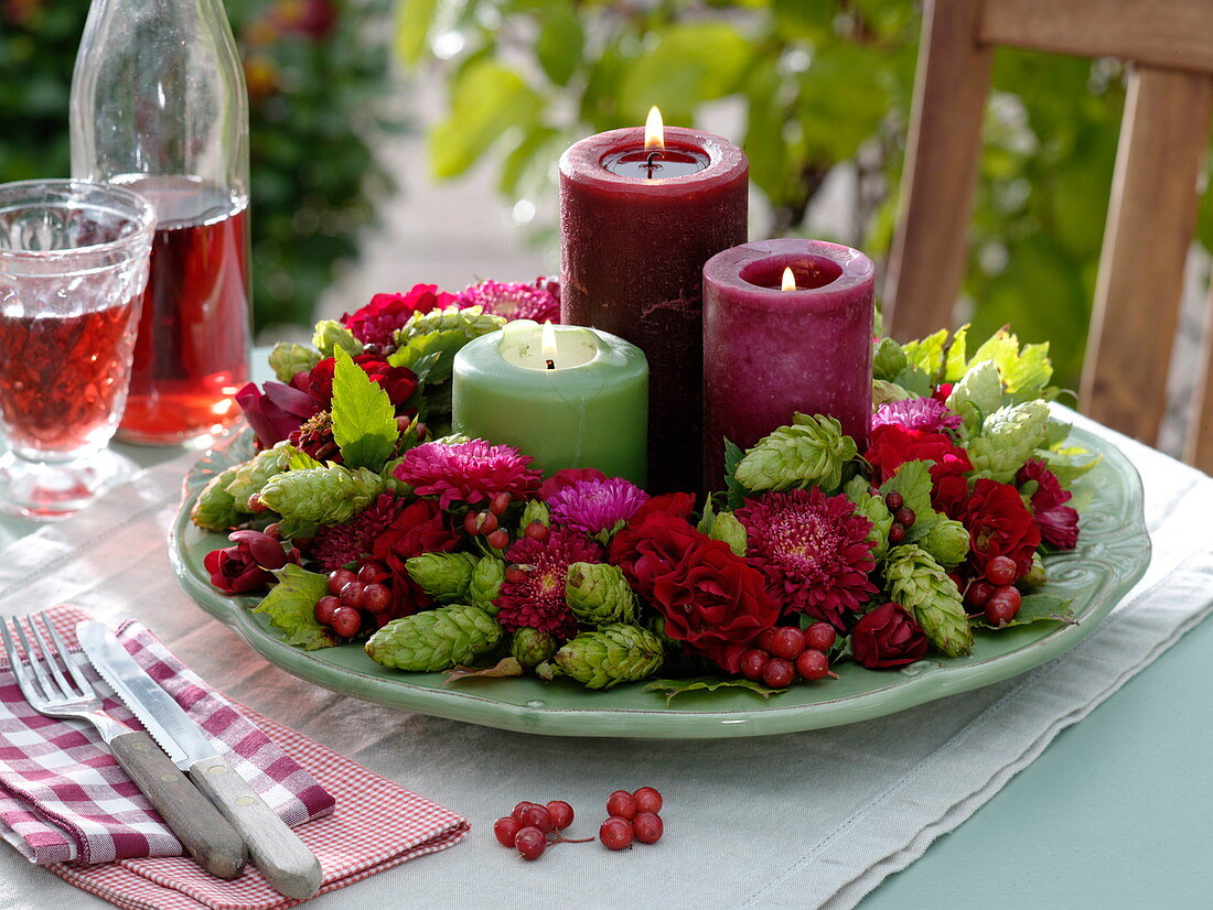 Late summer wreath with hops, roses, summer asters and candles