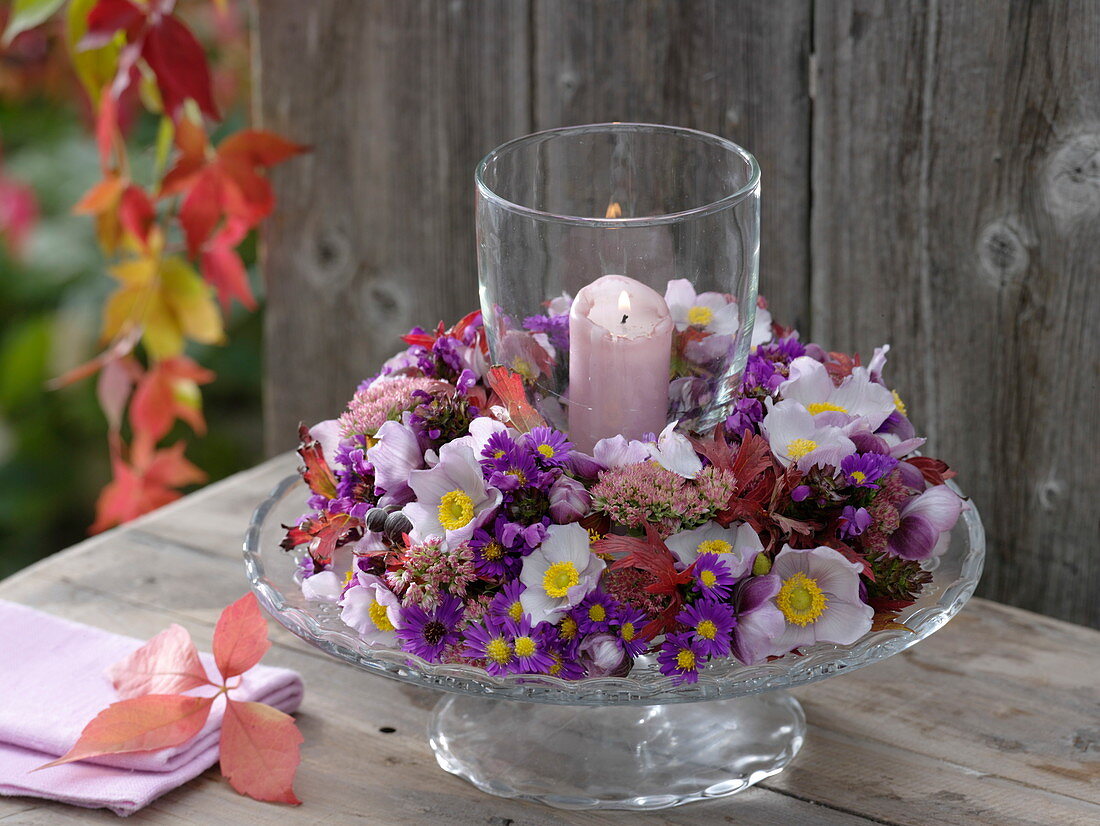 Glass wind light from autumn anemones, asters on footed glass plate