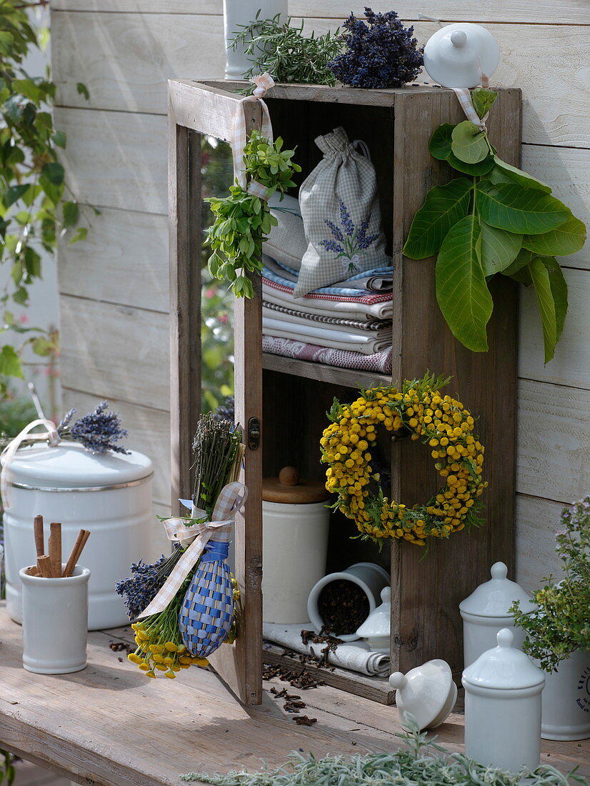 Wooden cabinet decorated with herbs on wooden table