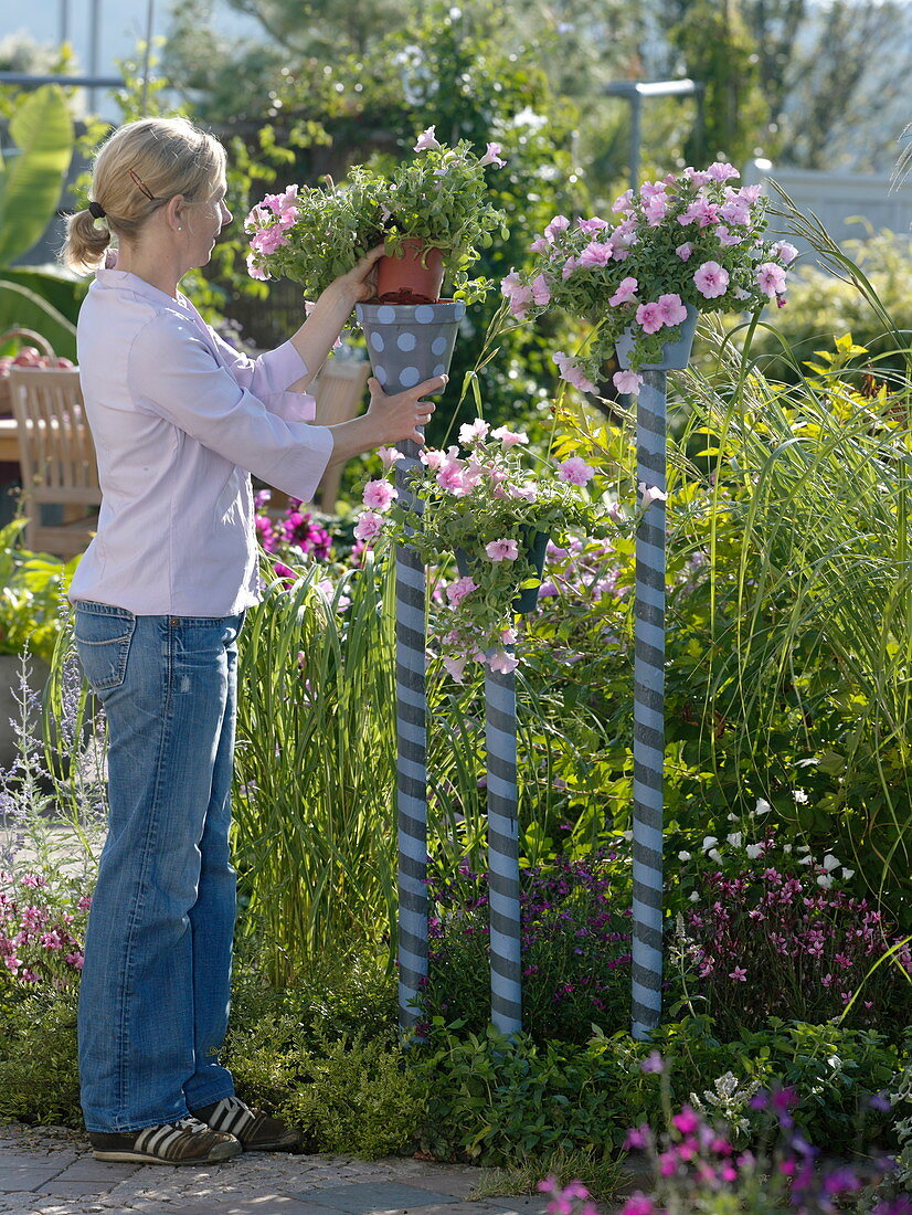 Painted pots on painted sticks in a flowerbed (9/10)