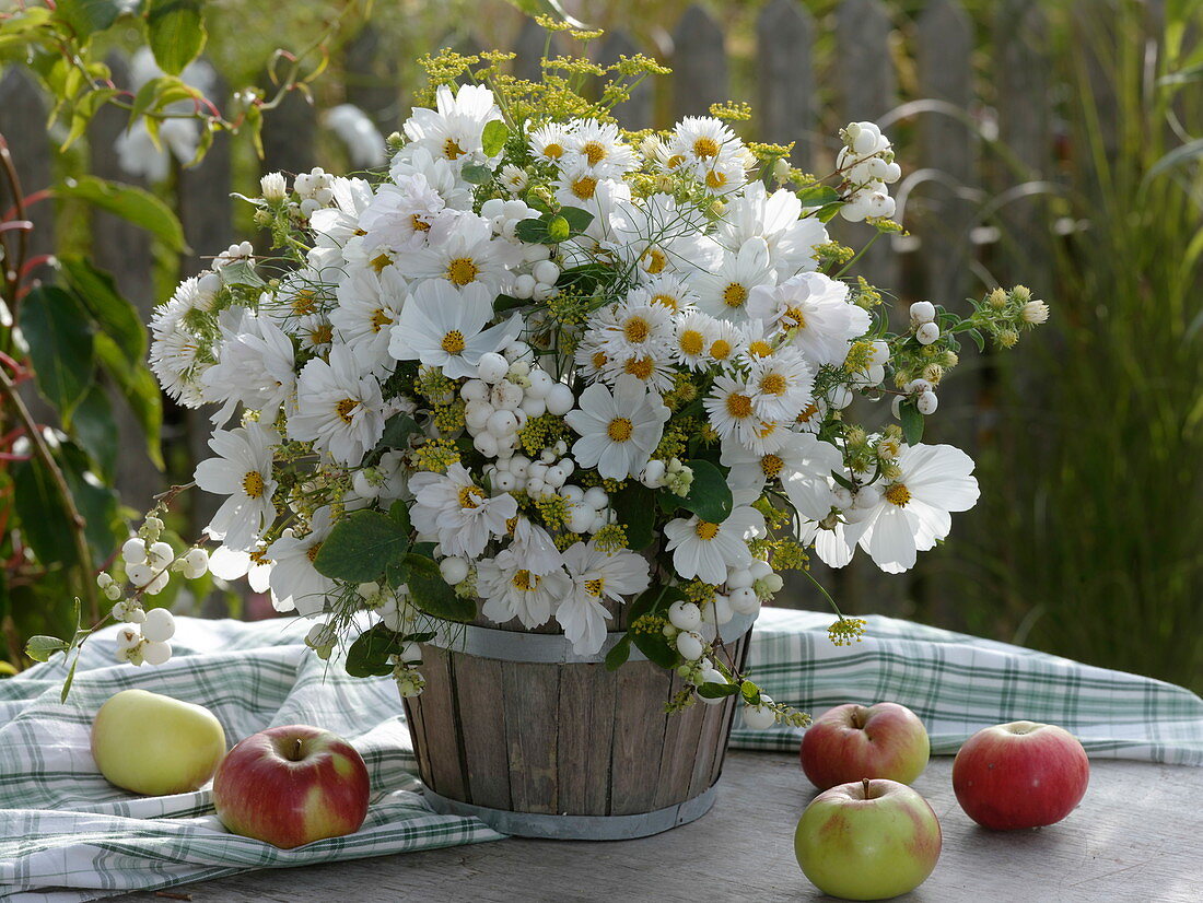 White autumnal bouquet in wooden containers on a table