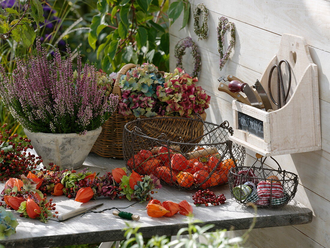 Work table in autumn with broom heather and fruit ornaments