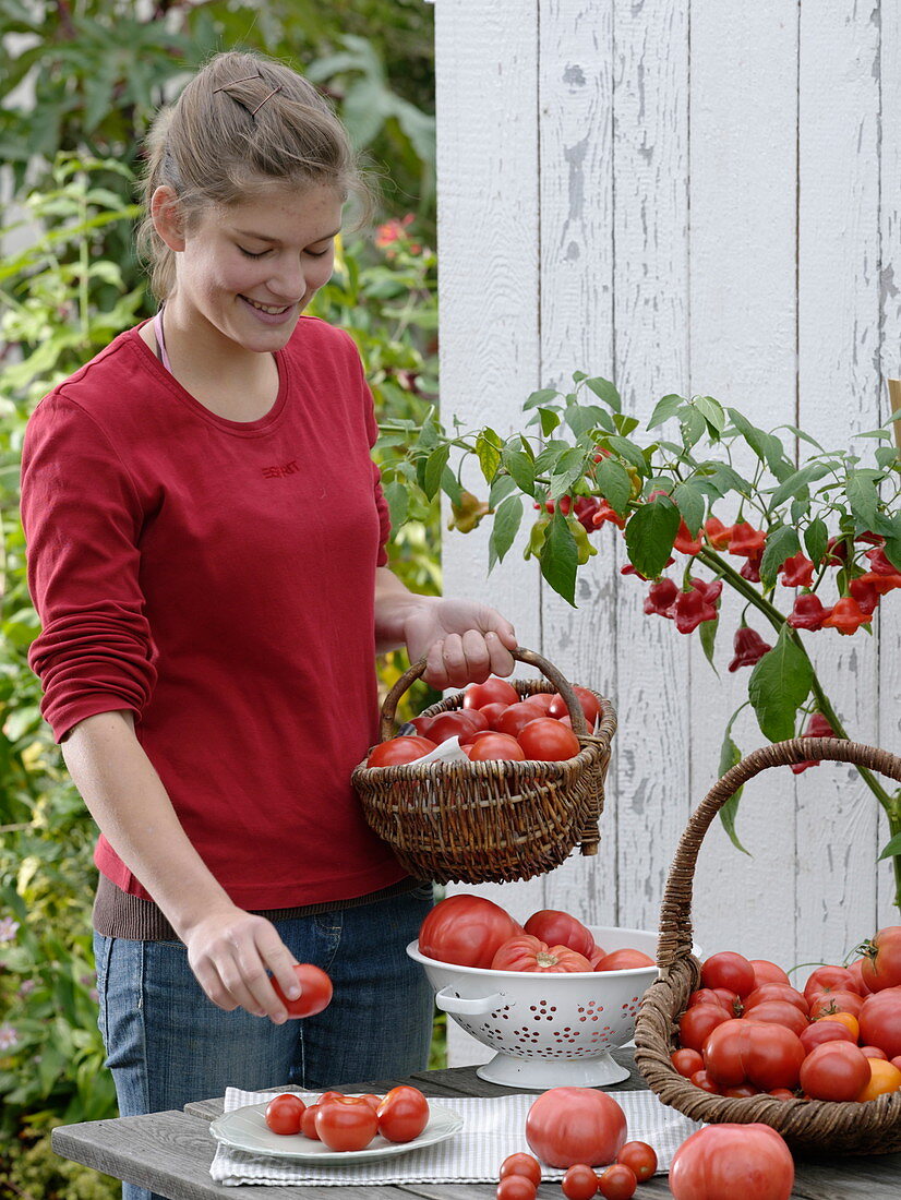 Young woman holding basket with tomatoes