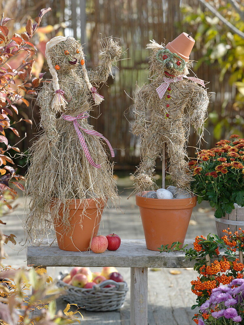 Autumn decoration on the terrace: pair made of hay in clay pots