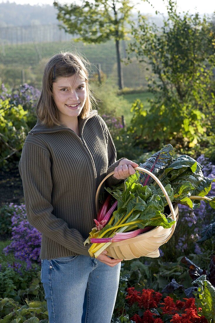 Young woman holding chard 'Bright Lights' basket