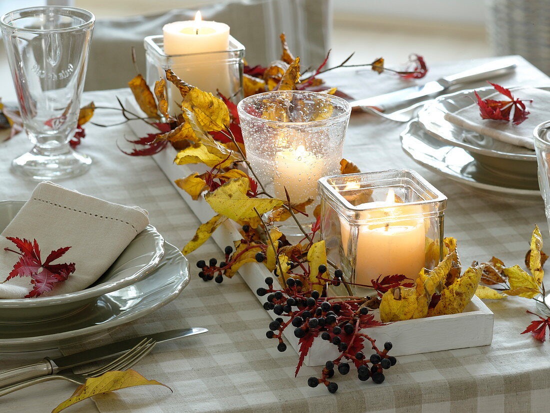 Fast, autumnal table decoration with red and yellow autumn leaves