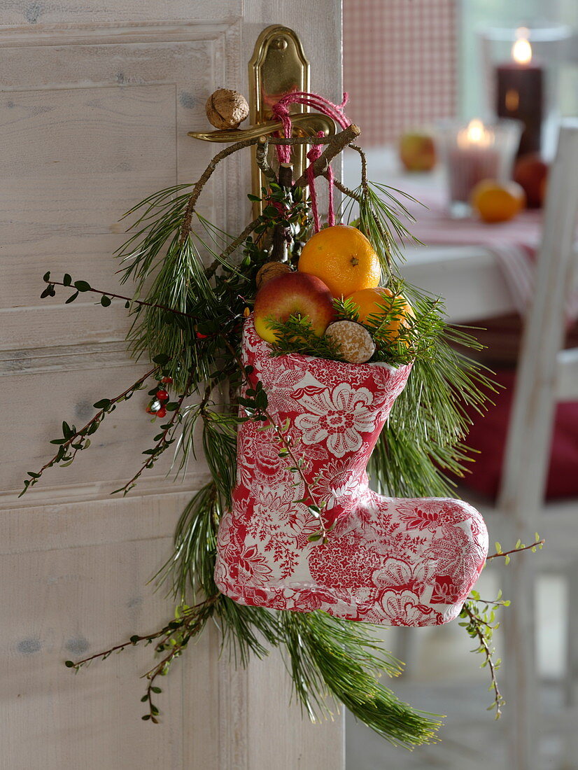 Red-white Nicholas boots made of papier-mâché, filled with oranges