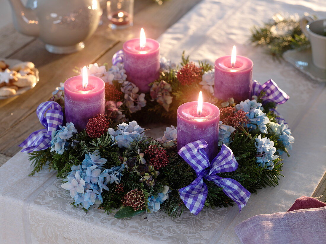 Ungewöhnlicher Adventkranz aus gemischtem Koniferengrün mit Blüten