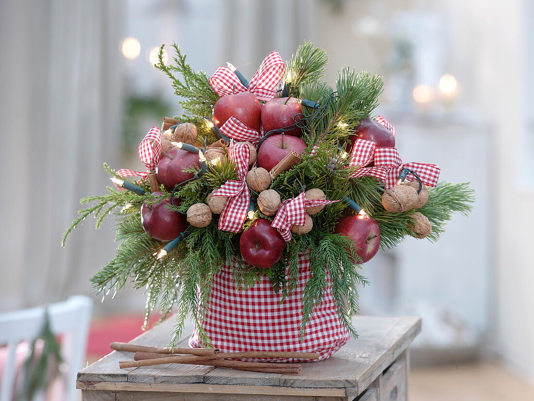 Weihnachtlicher Strauß mit Äpfeln (Malus), Walnüssen (Juglans), Pinus