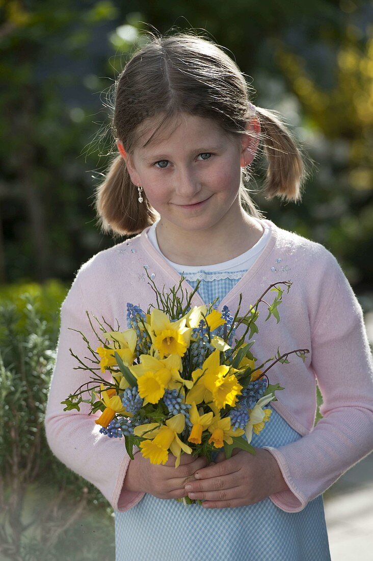 Girl with bouquet of Narcissus (daffodils, jonquils), Muscari