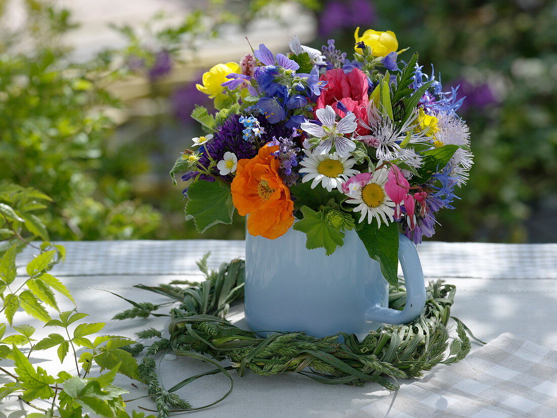 Bouquet of early summer flowers in an enamelled milk pot
