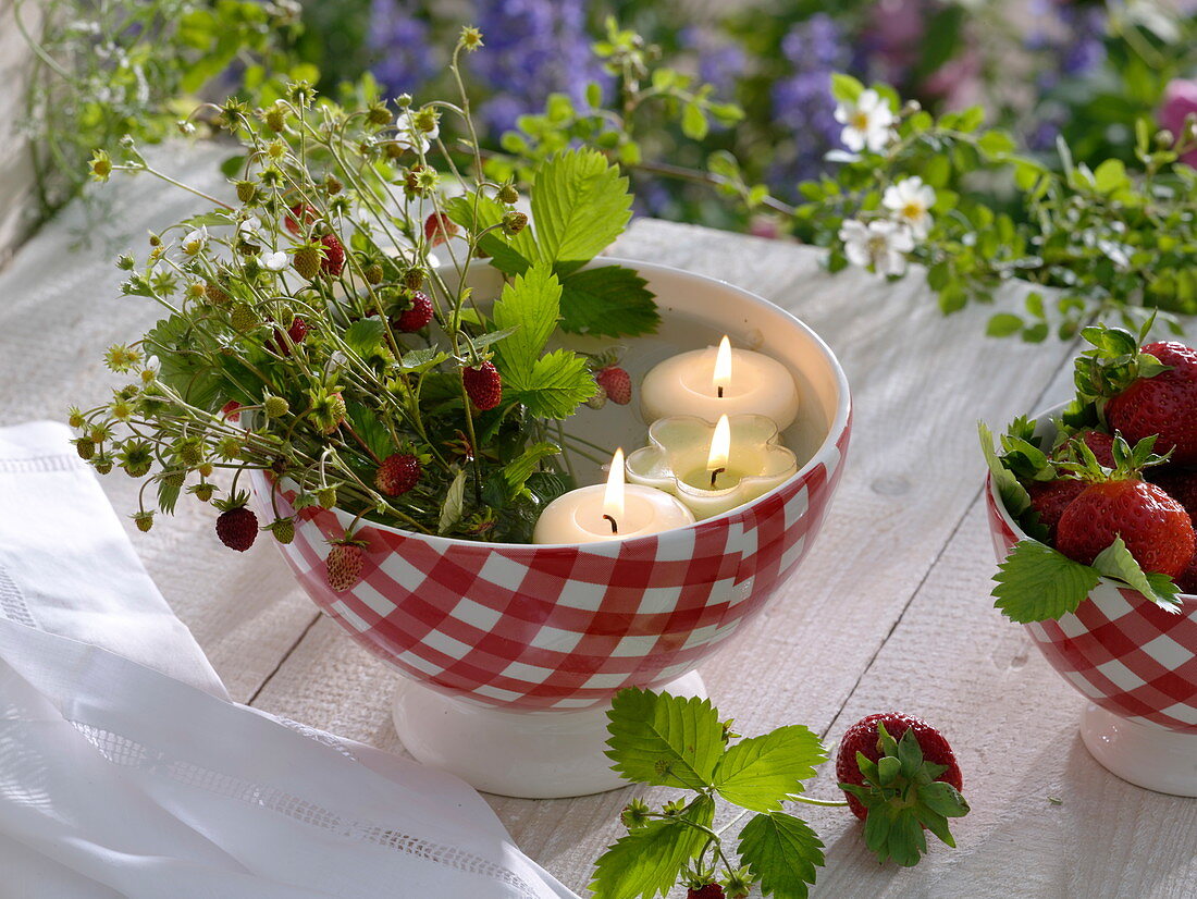 Wild strawberries (Fragaria vesca) with floating candles