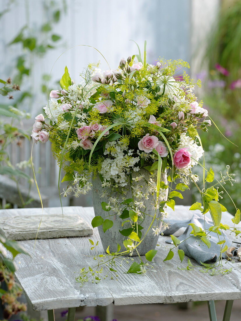 White-pink bouquet with roses, woody flowers and herbs