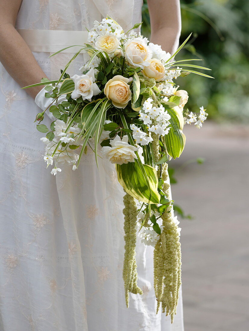 Woman with bridal bouquet of Rosa (roses), Solanum jasminoides
