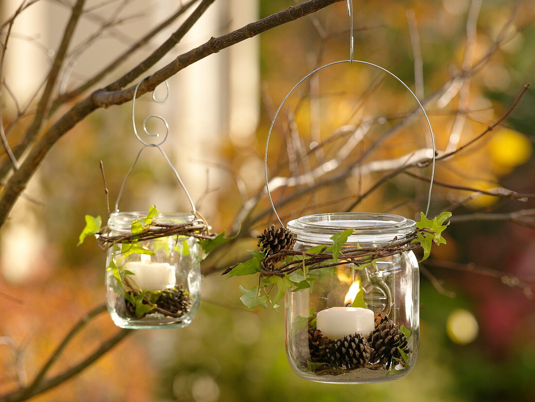 Canning jars as lanterns hung on a tree with a wire hanger