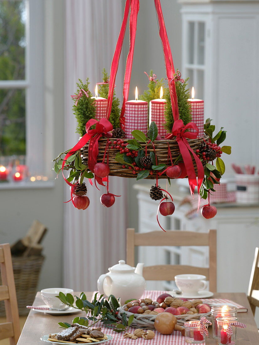 Hängender Adventskranz mit Äpfeln (Malus), Ilex (Stechpalme), Pinus