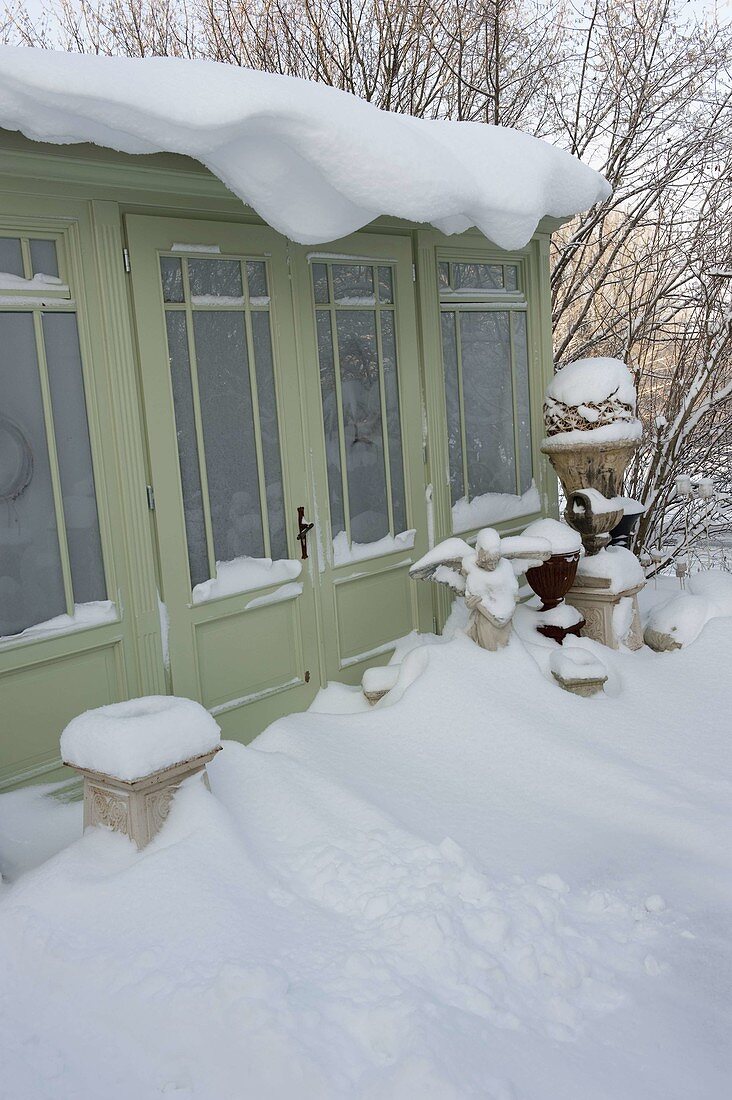 Snowy garden house with angels, amphorae and pedestals as decoration