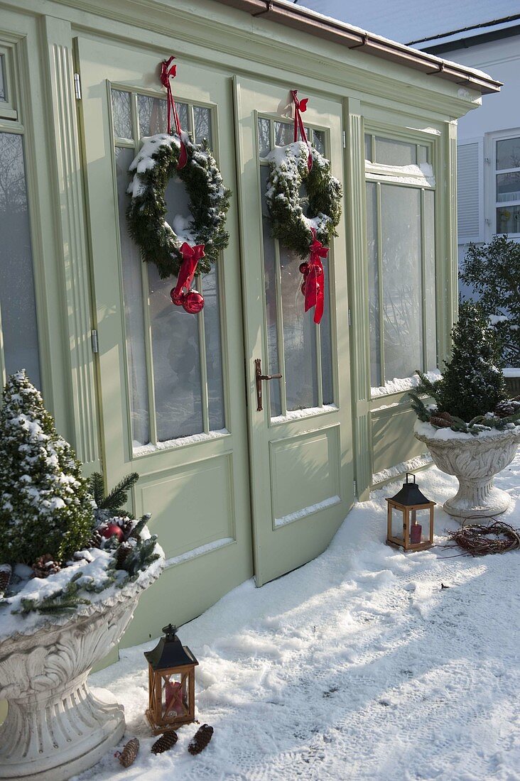 Snowy garden house decorated for Christmas with wreaths