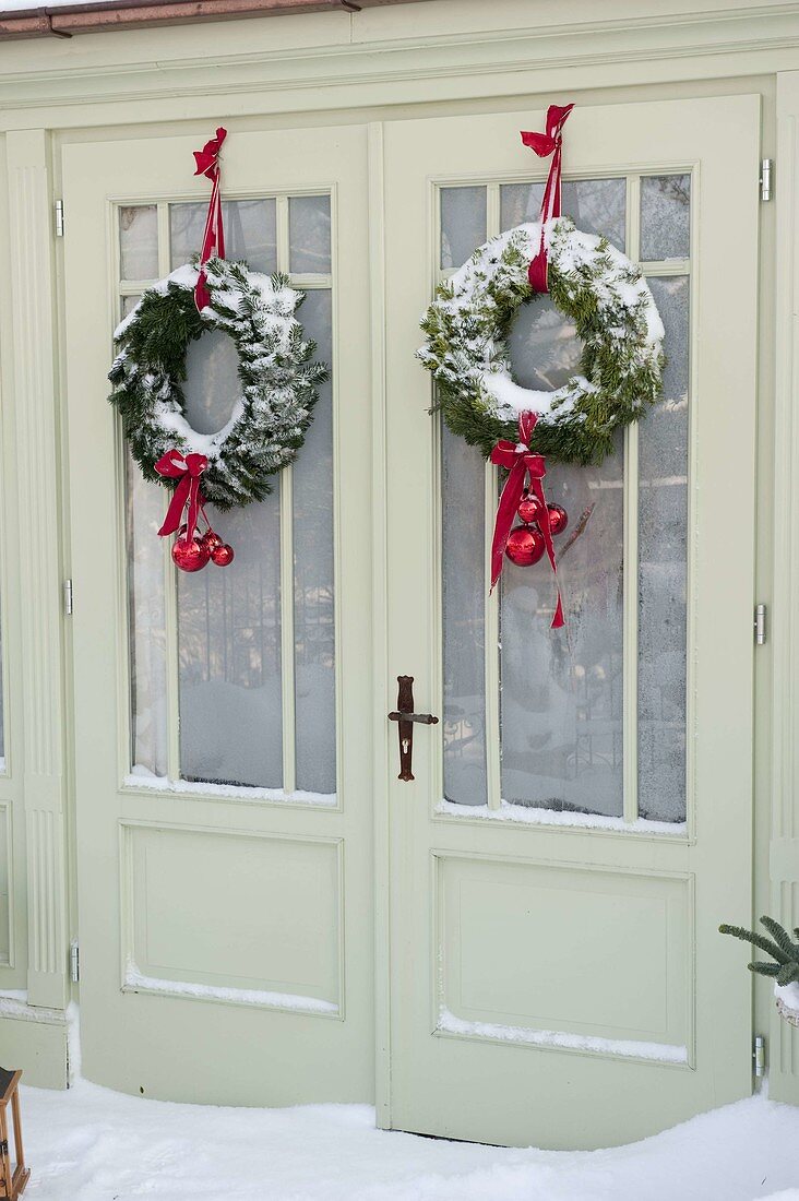 Snowy garden house decorated for Christmas with wreaths