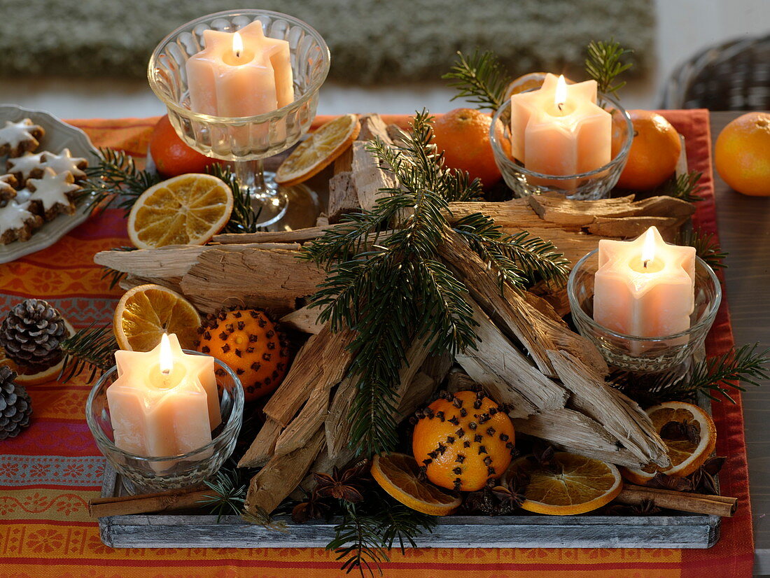 Unusual advent wreath with star candles in jars on wooden tray