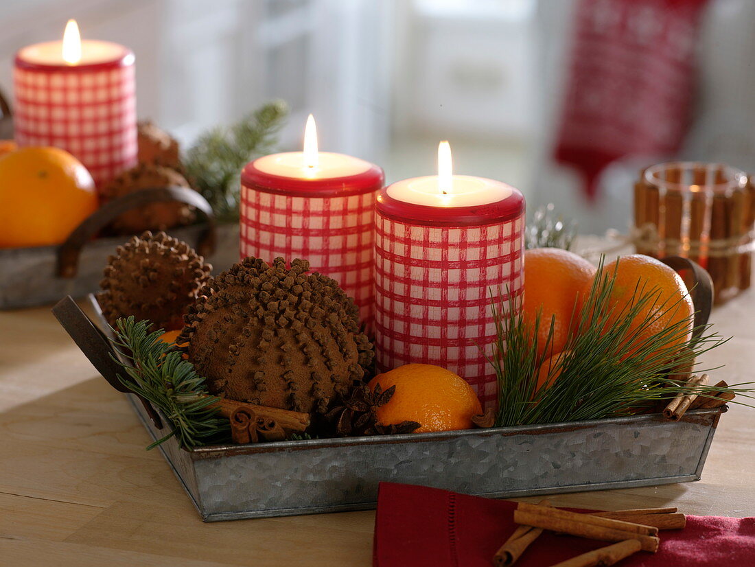 Zinc tray with red and white checked candles, pomander, oranges