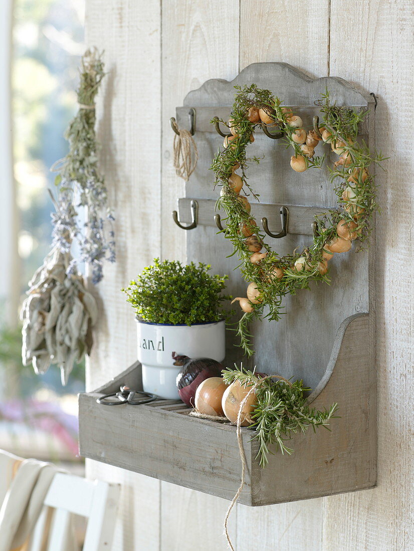 Heart of rosemary (Rosmarinus) and onions (Allium cepa) on wall shelf