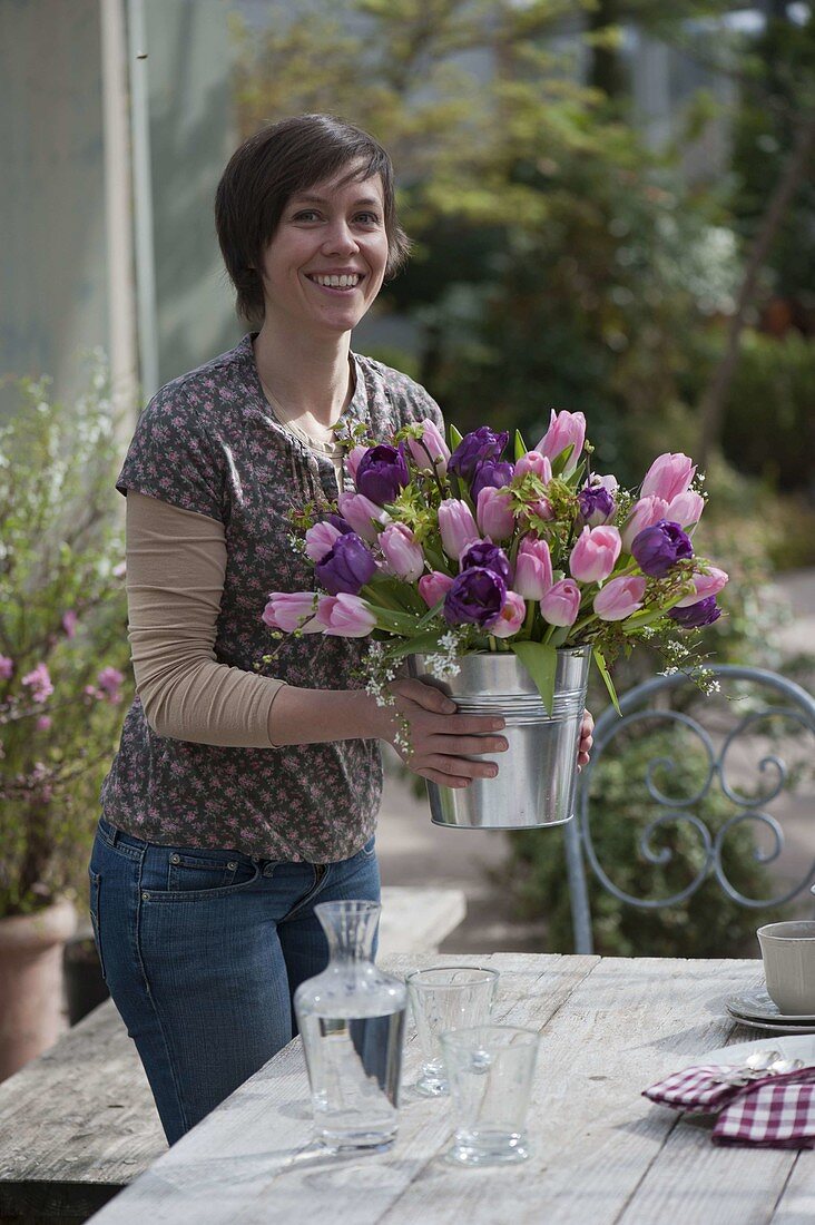 Woman with spring bouquet of tulips and woody twigs